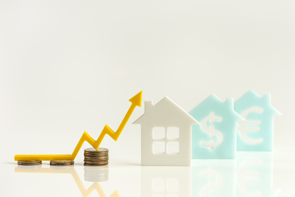 Real estate market, graph, up arrow. House model and a stack of coins. The concept of inflation, economic growth, the price of insurance services