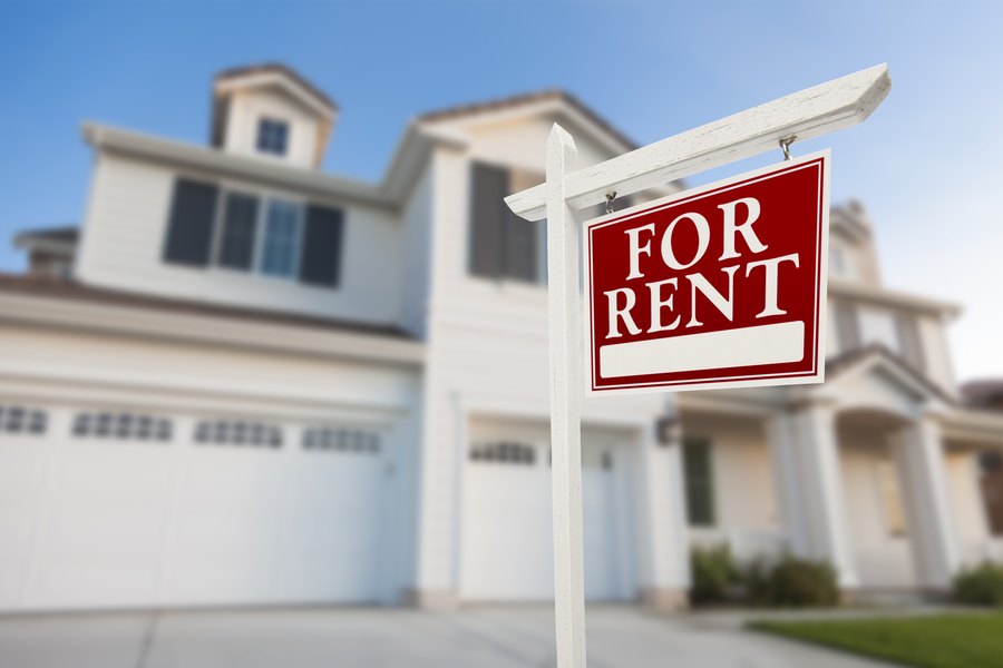 A for rent sign in front of a house.