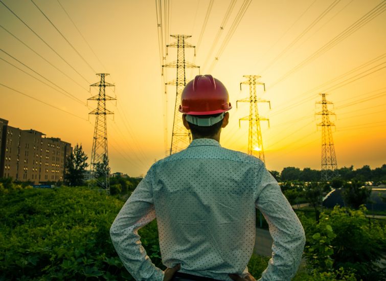 Electrical engineer inspecting power pole infrastructure to assess its condition and performance.