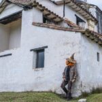 a-scarecrow-figure-leans-against-an-ancient-church-in-guasca-colombia-exuding-an-eerie-vibe