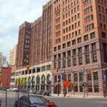 Historic brownstone buildings in an urban setting with clear skies.