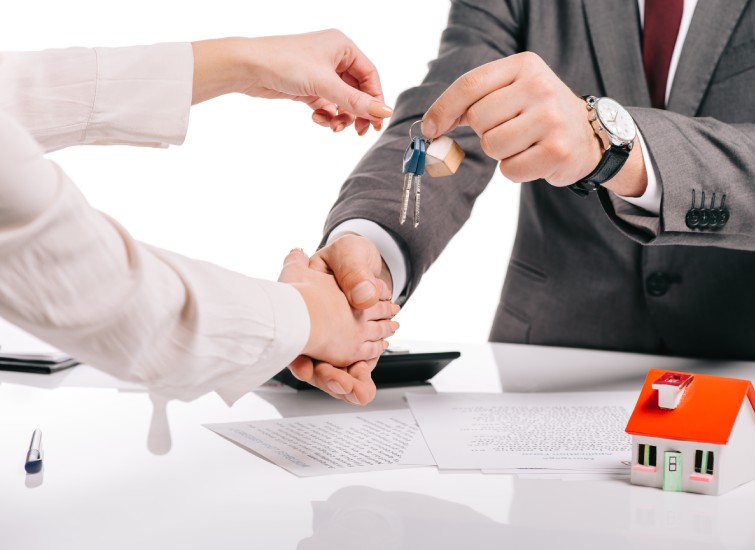 A man and woman handing over keys to a house, assessing credit score.