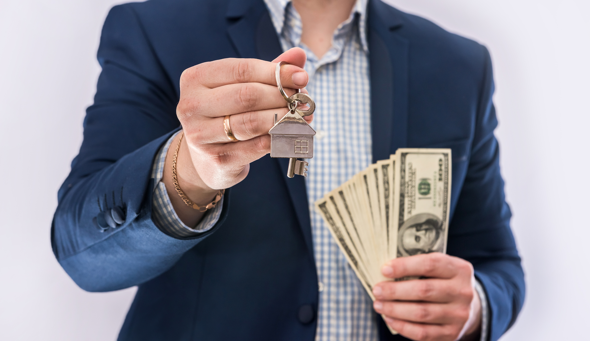 Male hands  holding US dollars bills and house key isolated