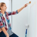 Young couple painting a wall in their home.