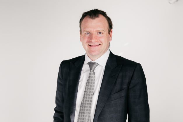 A man in a suit and tie posing for a photo.