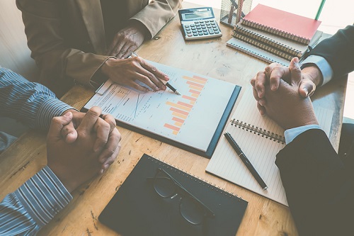 A group of business people sitting around a table.