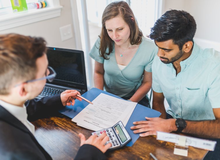 A group of investors sitting at a table looking at paperwork.