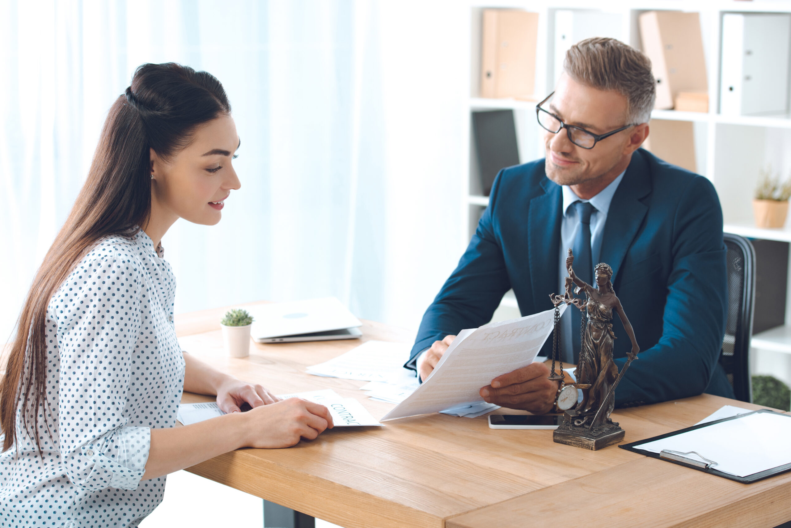 A man and a woman talking at a desk in an office.