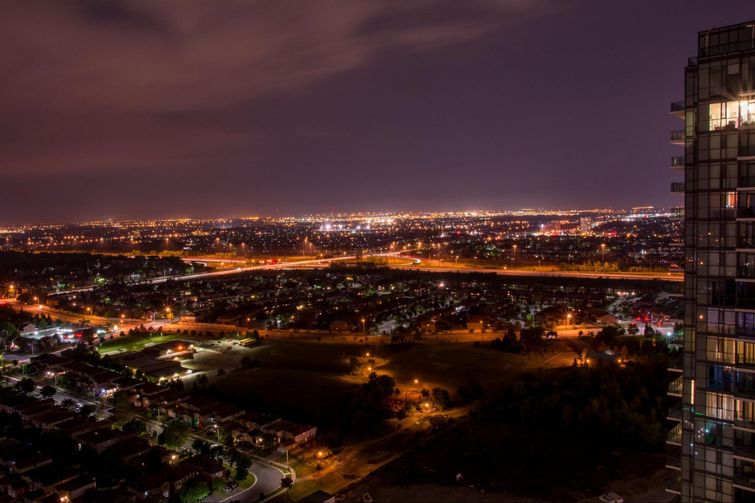 A view of the city at night from the top of a tall building.