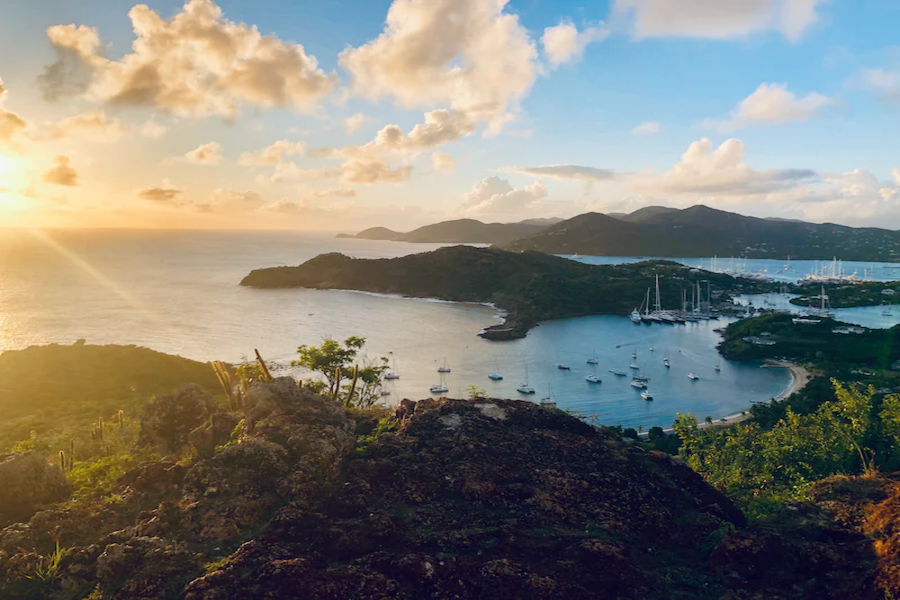 The sun is setting over a bay with boats in it.